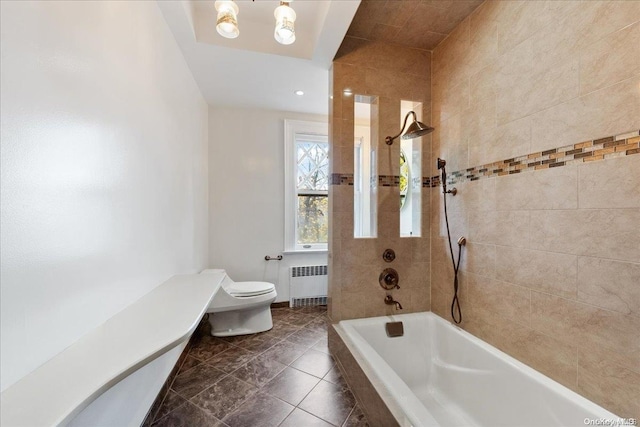 bathroom featuring tile patterned flooring, tiled shower / bath combo, toilet, and radiator