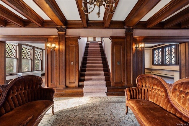 sitting room featuring decorative columns and beamed ceiling