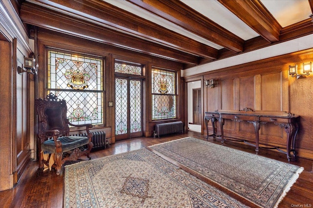 entrance foyer with wood walls, radiator heating unit, beamed ceiling, and ornamental molding