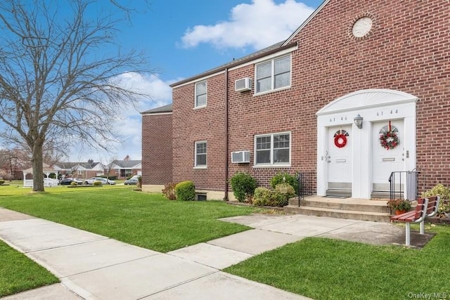 exterior space featuring a wall mounted AC and a yard