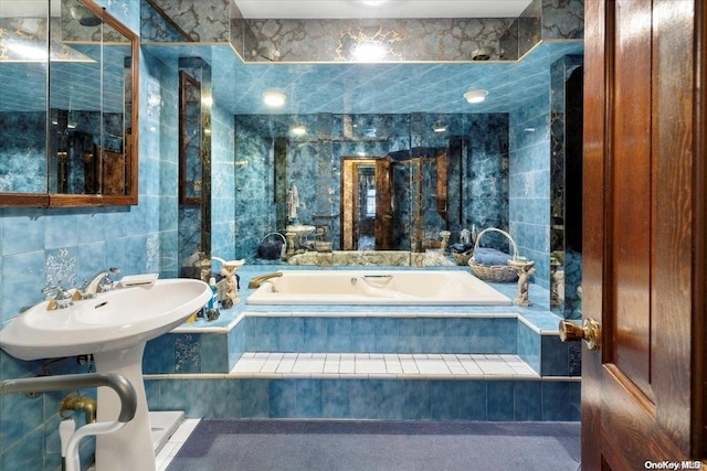 full bathroom with tiled tub and tile walls