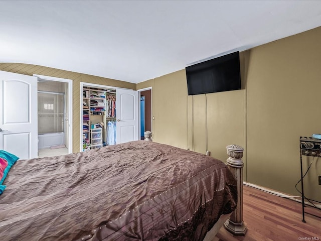 bedroom with connected bathroom, a closet, and wood-type flooring