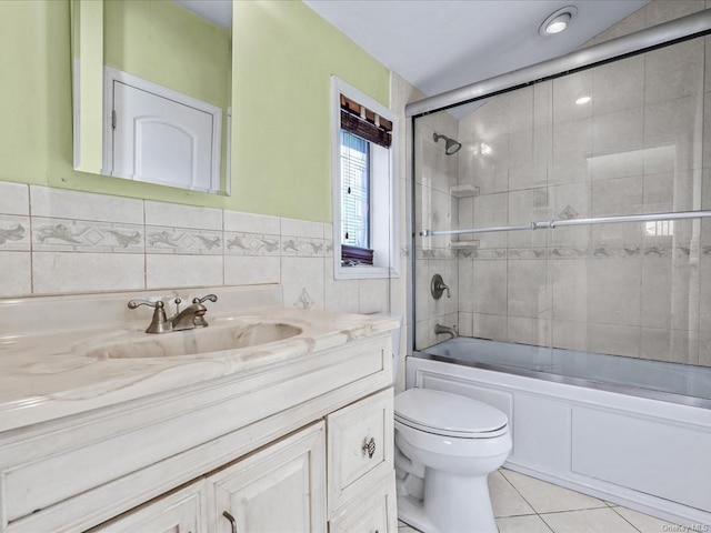 full bathroom featuring tile patterned floors, vanity, tile walls, enclosed tub / shower combo, and toilet