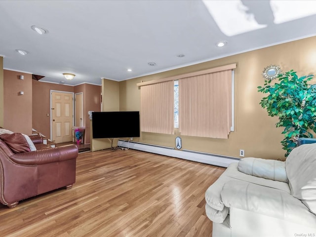 living room featuring light wood-type flooring, baseboard heating, and ornamental molding