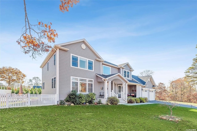 view of front of property with a garage, covered porch, and a front lawn