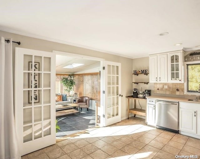 kitchen featuring stainless steel dishwasher, light tile patterned flooring, white cabinets, and sink