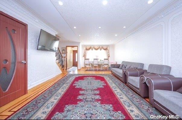 living room featuring a textured ceiling and ornamental molding