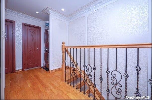 hall with crown molding and light hardwood / wood-style flooring