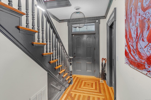 entrance foyer featuring parquet floors and ornamental molding