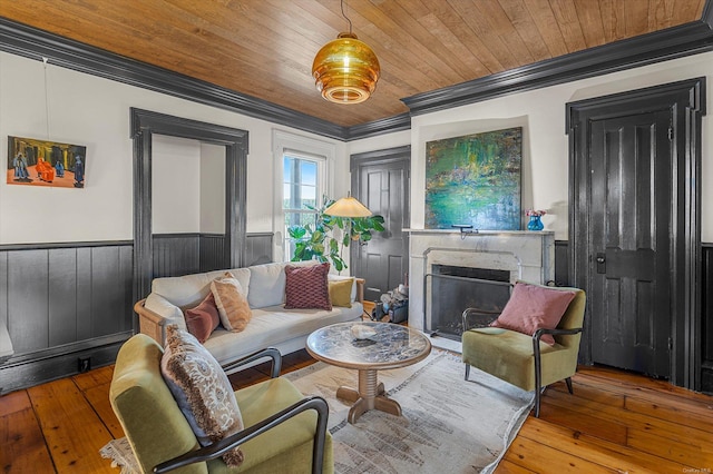 living room featuring a premium fireplace, hardwood / wood-style flooring, ornamental molding, and wood ceiling