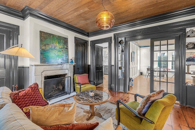 living room with light wood-type flooring, wooden ceiling, crown molding, and a premium fireplace