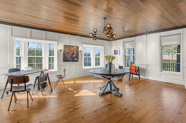 dining area with a notable chandelier, light hardwood / wood-style floors, and wooden ceiling