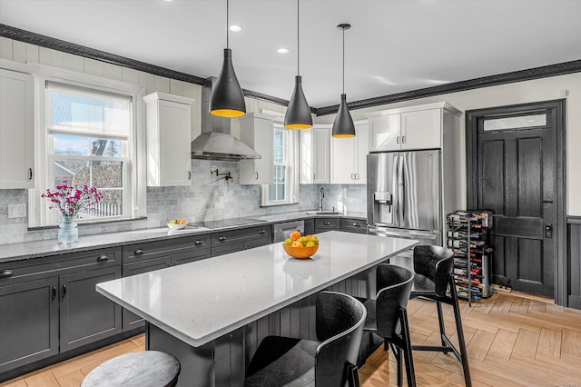 kitchen featuring pendant lighting, a kitchen island, white cabinetry, and appliances with stainless steel finishes