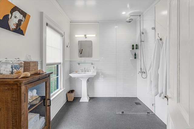 bathroom featuring tile patterned flooring, a shower with door, ornamental molding, and tile walls