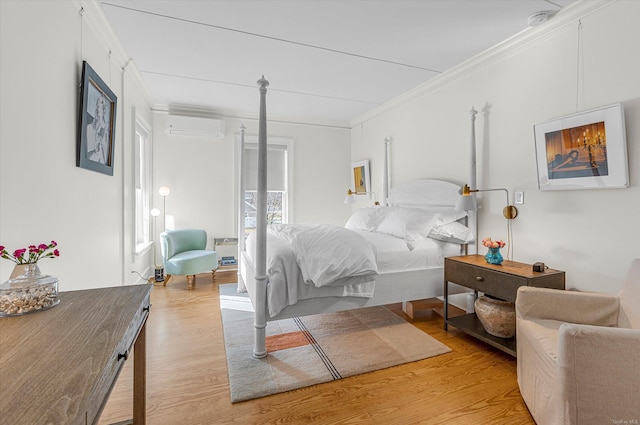 bedroom with an AC wall unit, crown molding, and light hardwood / wood-style flooring