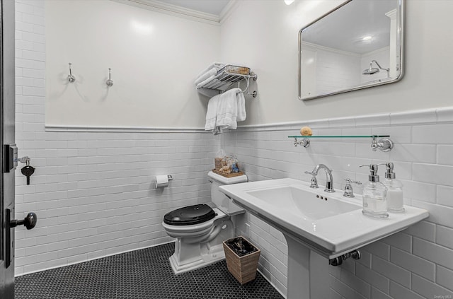 bathroom with tile patterned floors, crown molding, sink, tile walls, and toilet