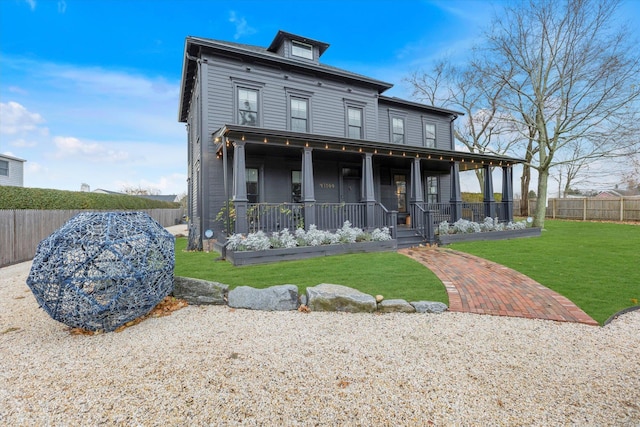 back of property with a lawn and covered porch