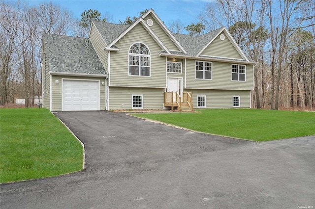 raised ranch featuring a garage and a front yard