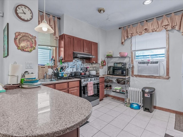 kitchen featuring radiator, stainless steel range with gas cooktop, sink, decorative light fixtures, and light tile patterned flooring