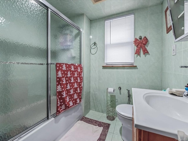 full bathroom with tile patterned floors, vanity, enclosed tub / shower combo, and tile walls