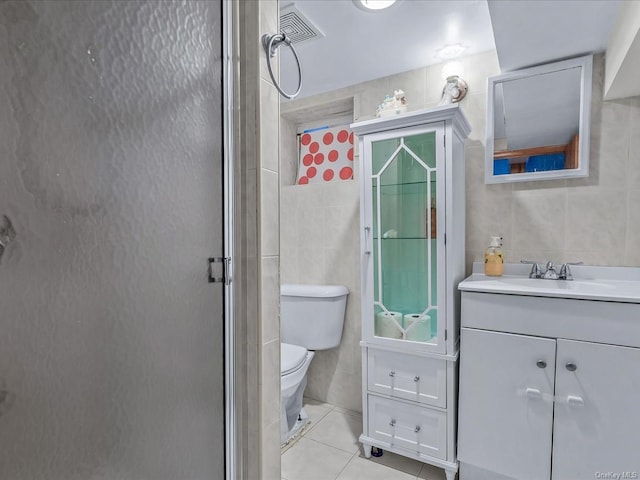 bathroom with tile patterned floors, vanity, tile walls, and walk in shower