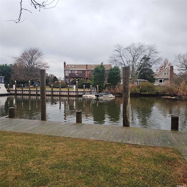 dock area featuring a lawn and a water view