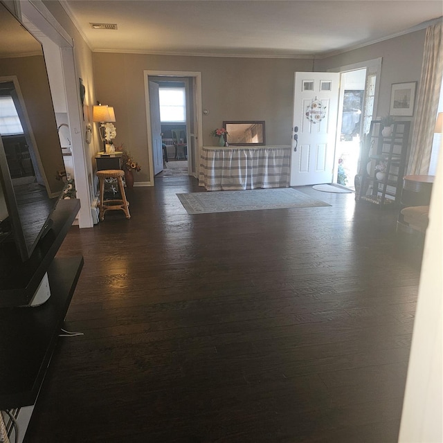 entrance foyer with dark hardwood / wood-style flooring and crown molding