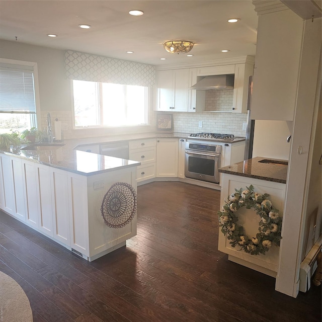 kitchen with white cabinets, stainless steel appliances, dark wood-type flooring, and stone countertops