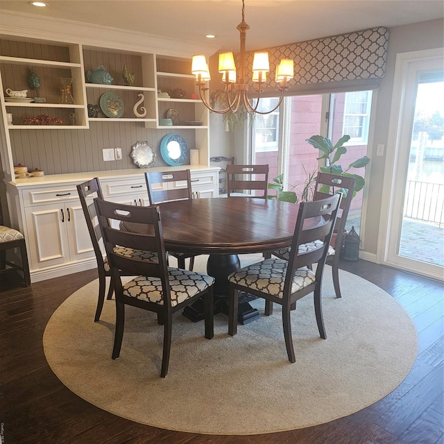 dining space with dark hardwood / wood-style floors and a chandelier