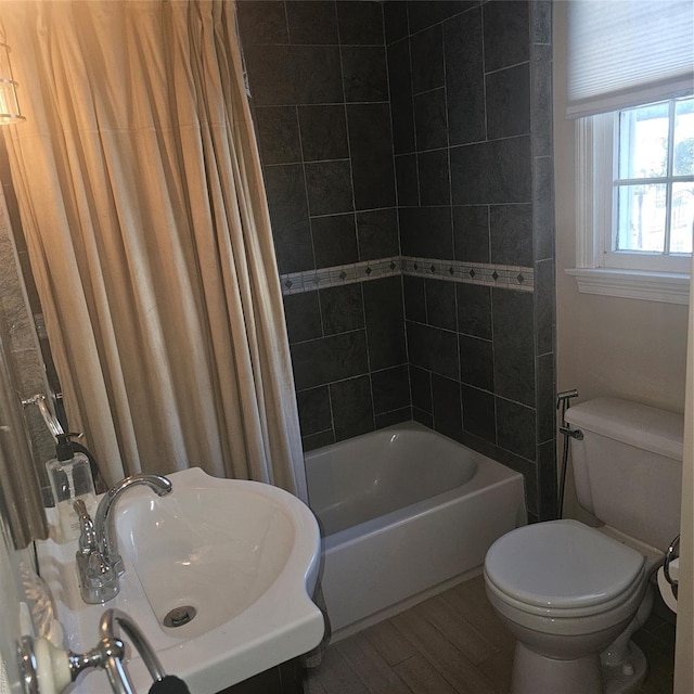 full bathroom featuring hardwood / wood-style flooring, sink, shower / bath combination with curtain, and toilet