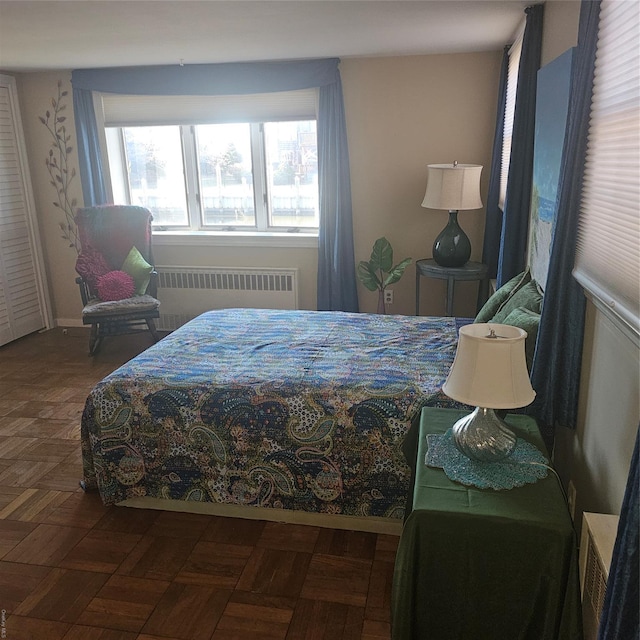 bedroom featuring radiator heating unit and dark parquet floors