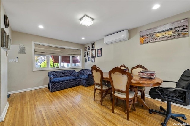 dining space featuring light hardwood / wood-style flooring and a wall mounted air conditioner