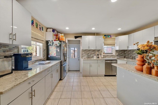 kitchen with decorative backsplash, white cabinetry, sink, and appliances with stainless steel finishes