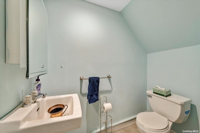 bathroom featuring toilet, lofted ceiling, and sink