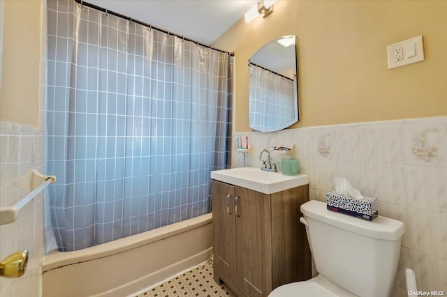 full bathroom with tile patterned flooring, toilet, shower / tub combo with curtain, vanity, and tile walls