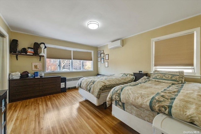 bedroom with a wall unit AC, radiator, light hardwood / wood-style floors, and ornamental molding