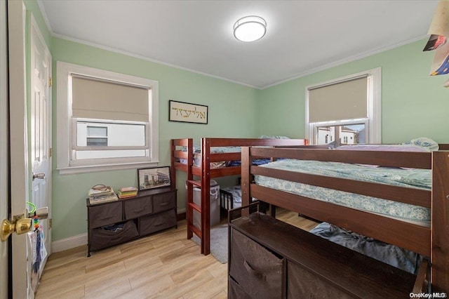 bedroom with light wood-type flooring and crown molding