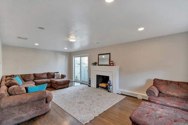 living room featuring dark hardwood / wood-style floors and a baseboard heating unit