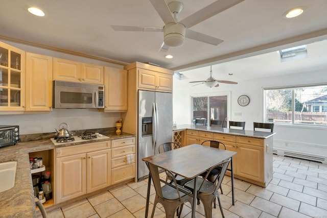 kitchen featuring light stone countertops, light brown cabinets, and stainless steel appliances