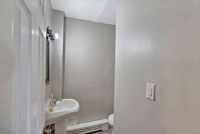 bathroom with a baseboard radiator and toilet