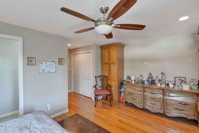 bedroom with a closet, light hardwood / wood-style floors, and ceiling fan