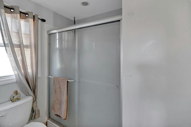 bathroom with toilet and a shower with shower door