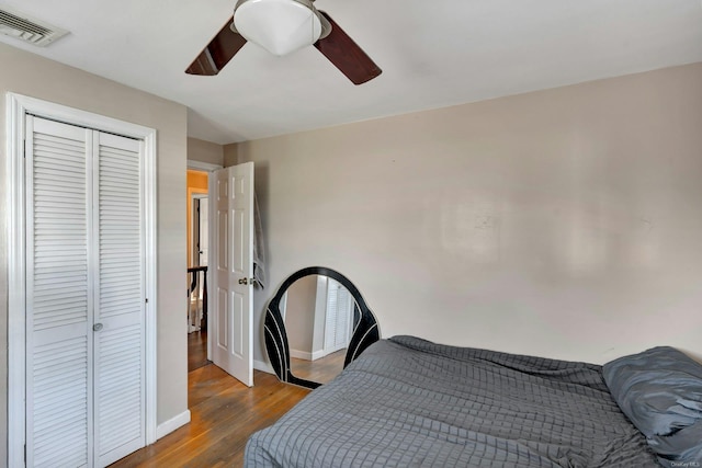 bedroom featuring ceiling fan, a closet, and dark hardwood / wood-style floors