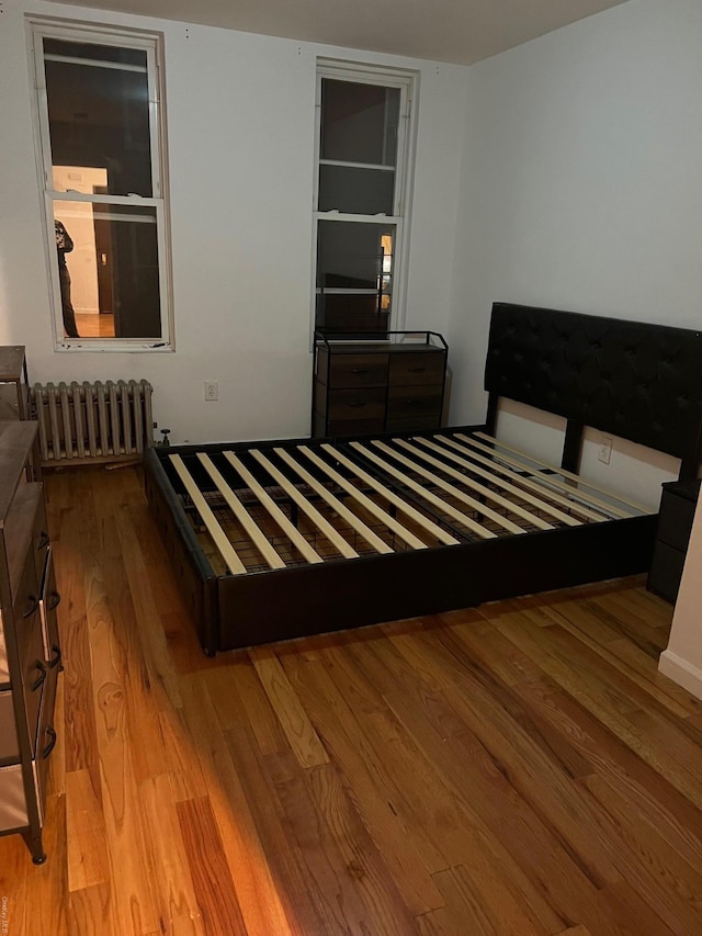 bedroom with light hardwood / wood-style flooring and radiator