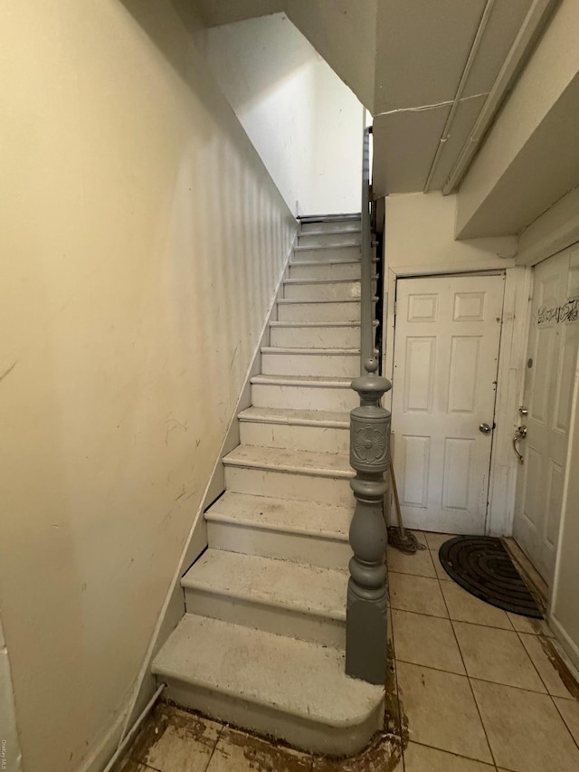 stairway featuring tile patterned flooring