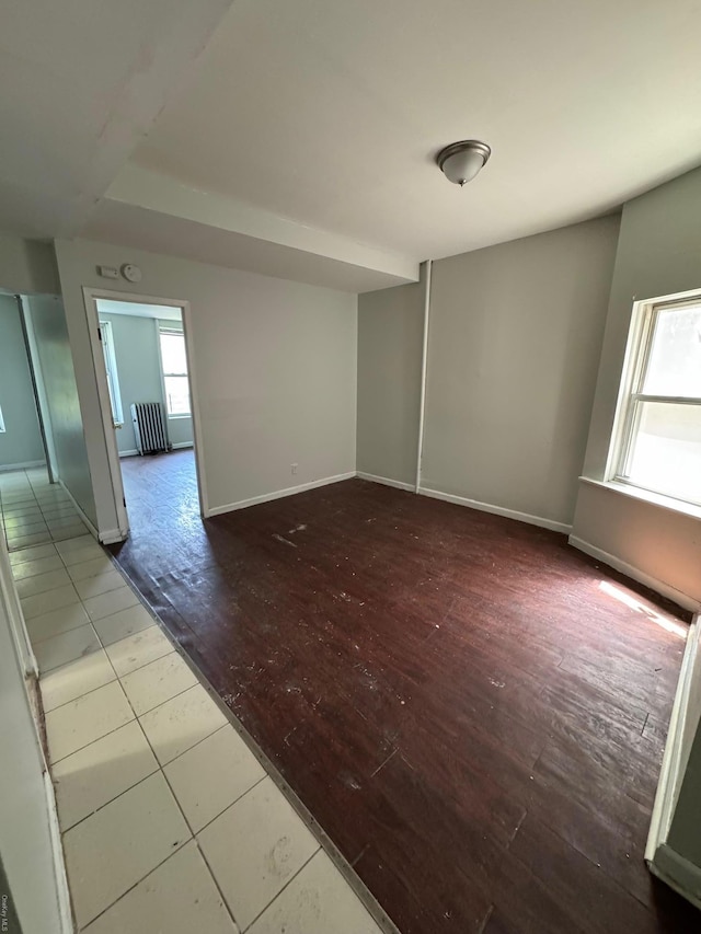 spare room with wood-type flooring and a healthy amount of sunlight