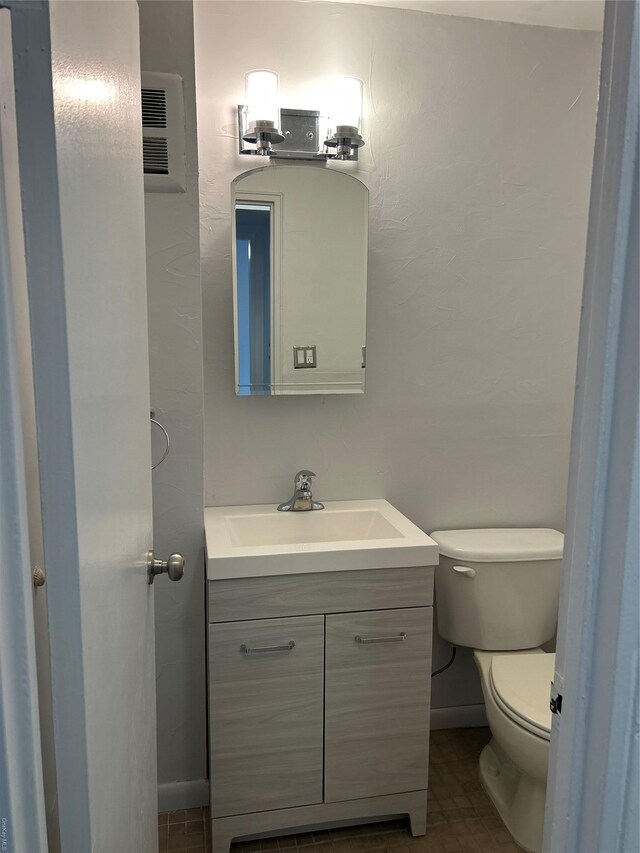 bathroom featuring tile patterned flooring, vanity, and toilet