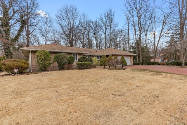 ranch-style house with a garage, driveway, and a front lawn