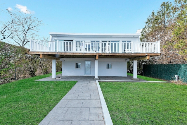 back of house featuring a wooden deck, a patio area, and a lawn