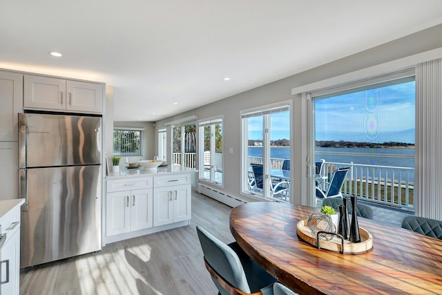 kitchen with white cabinetry, stainless steel refrigerator, and a wealth of natural light